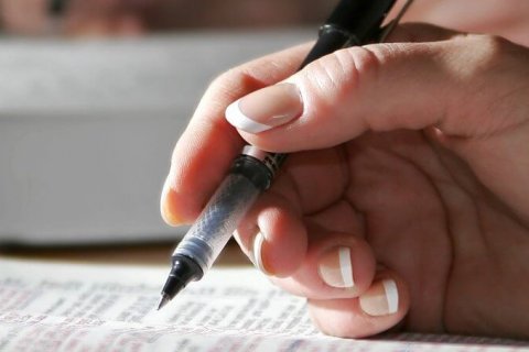 Woman's hand making notes in a Bible